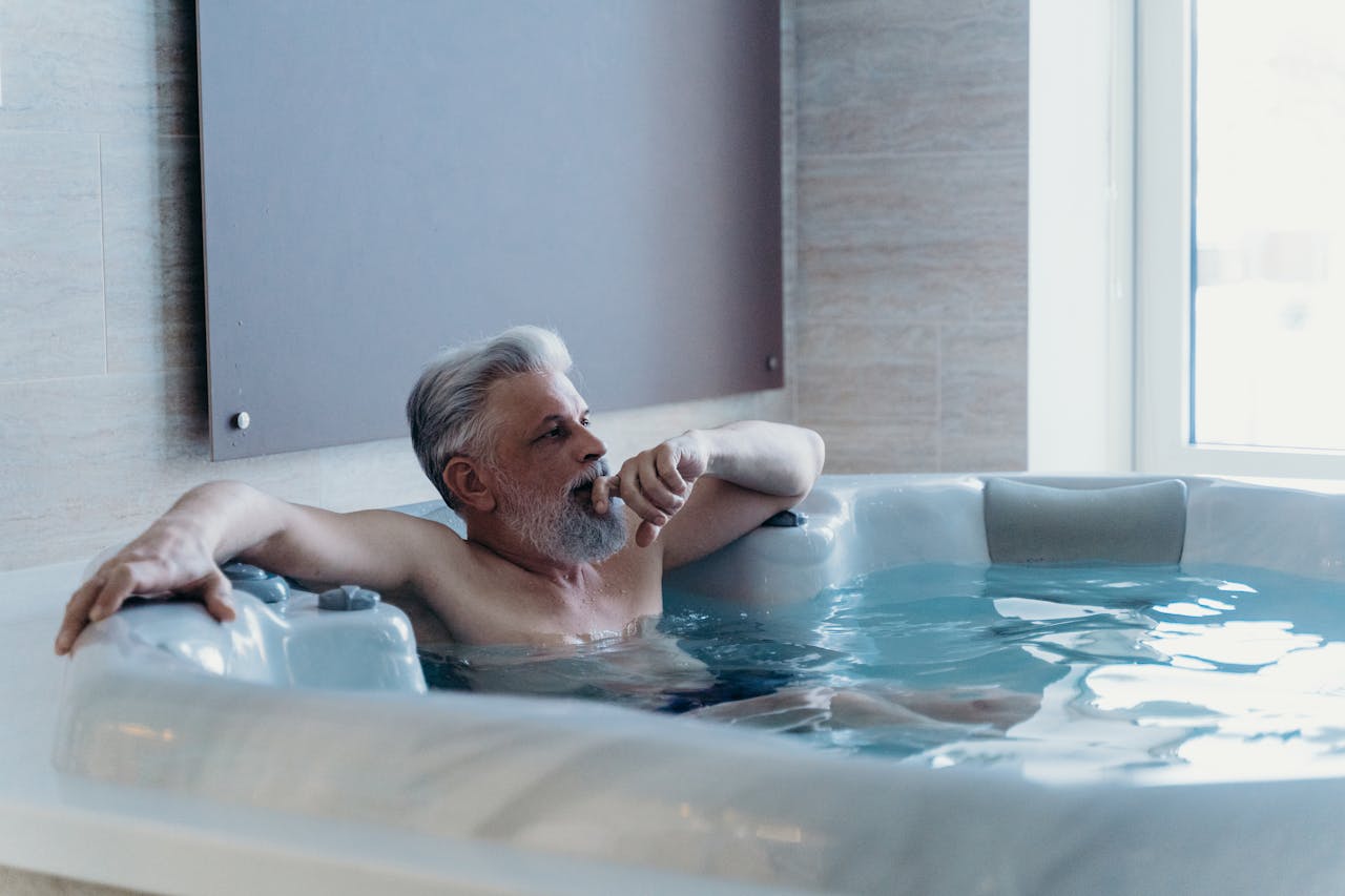 Home Elderly man enjoying relaxation in an indoor jacuzzi spa setting.
